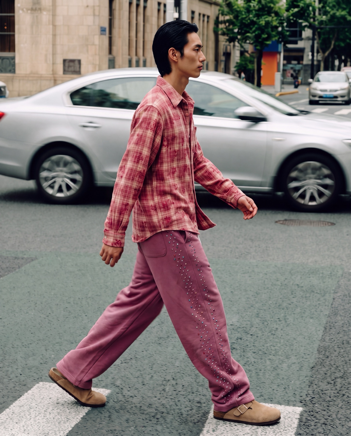 Model wearing a pink checked JACI look while crossing a city street